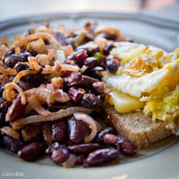 Fried egg and cheese sandwich with warm kidney bean and caramelized onion salad
